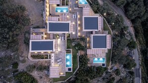 Een modern wooncomplex met meerdere units, diverse zwembaden, buitenzitplekken en een goed onderhouden tuin.