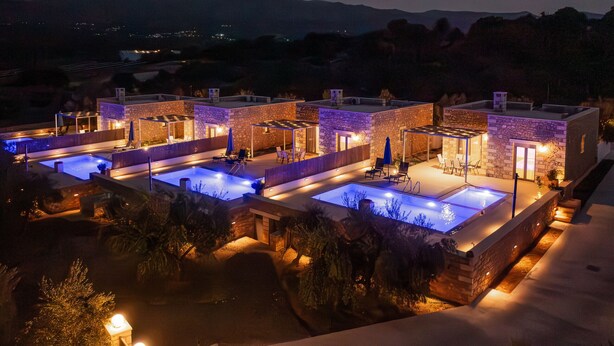 A hotel with multiple pools, stone architecture, and a view of mountains. - Melidoni Villas (Mylopotamos)