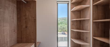 Ein modernes Interieur mit Holzbögen und Blick auf eine gebirgige Landschaft durch eine Glastür.