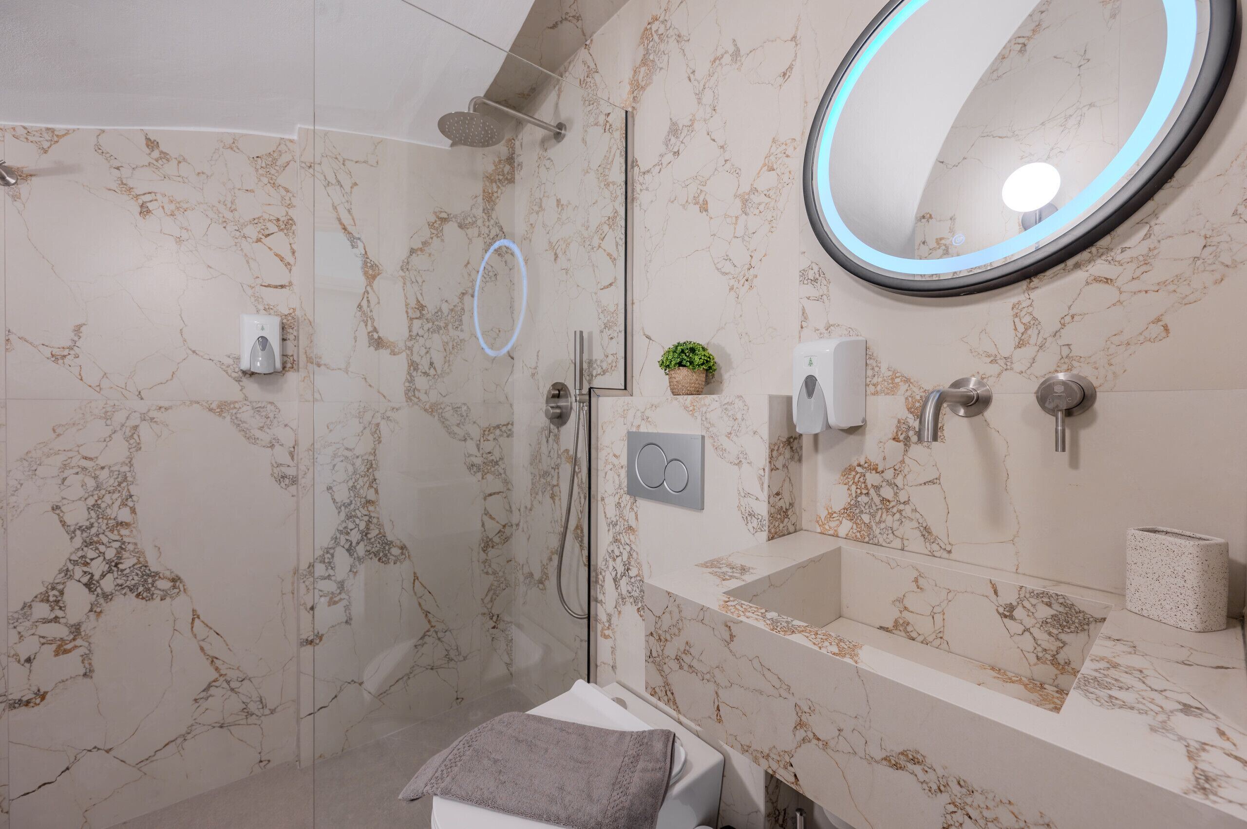 A bathroom with a shower, a sink, a mirror, and a towel rack.