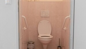 A small, modern bathroom with a toilet, a trash bin, and a bidet. - Modern 2BR Apt. Perfect for Long and Short Stays (Wien)