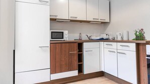A modern kitchen with white cabinets, a microwave, a coffee maker, and a sink. - Modern 2BR Apt. Perfect for Long and Short Stays (Wien)