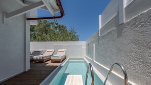 A rectangular pool with a wooden deck, lounge chairs, and a metal ladder. - Aloe (Rethymno)
