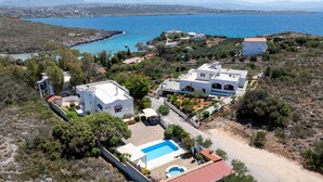 A coastal property with multiple buildings, a swimming pool, and a view of the sea. - Villa Plumeria Flower (Chania)