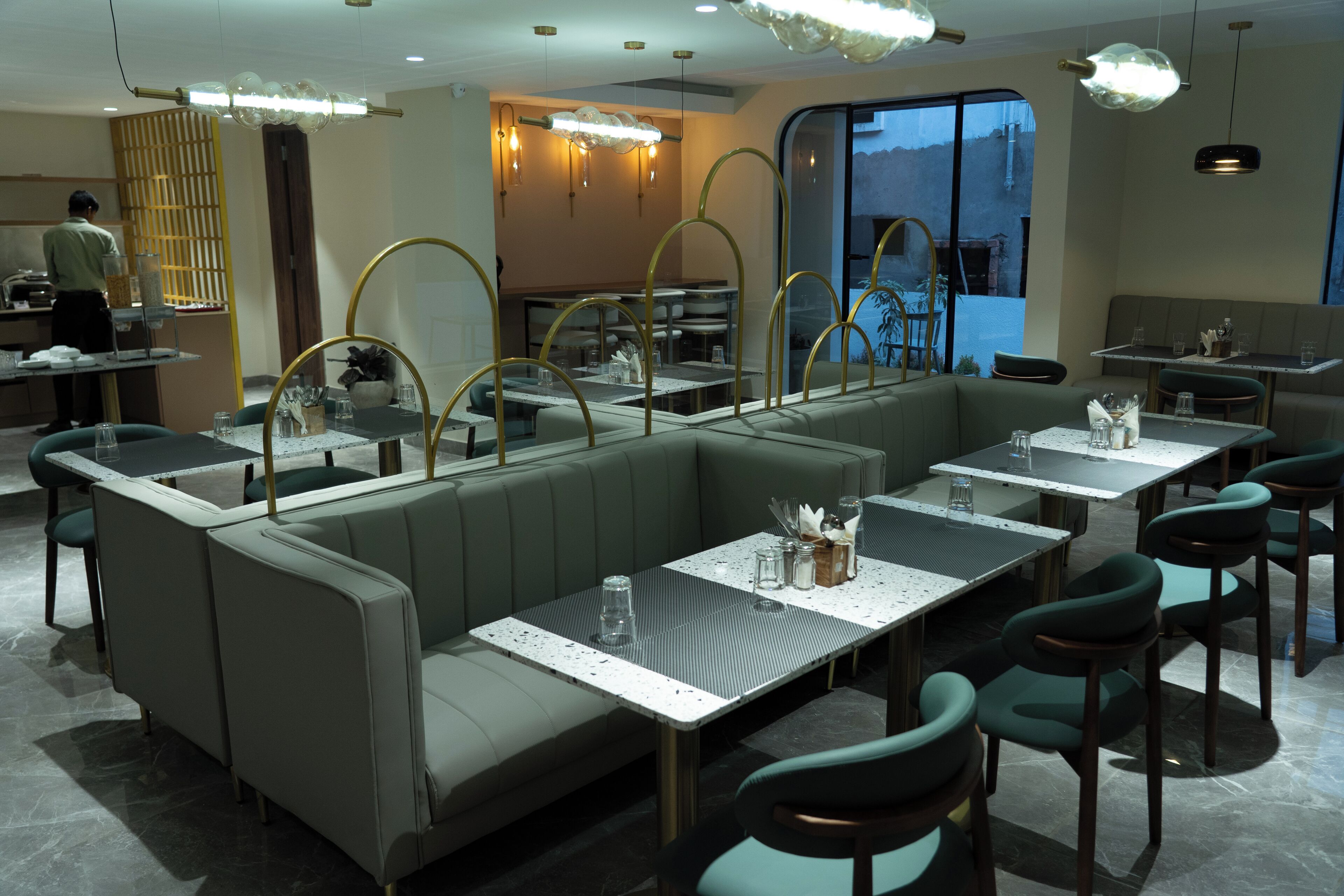 Un restaurante moderno con asientos tipo cabina, una zona de bar y vistas al exterior.