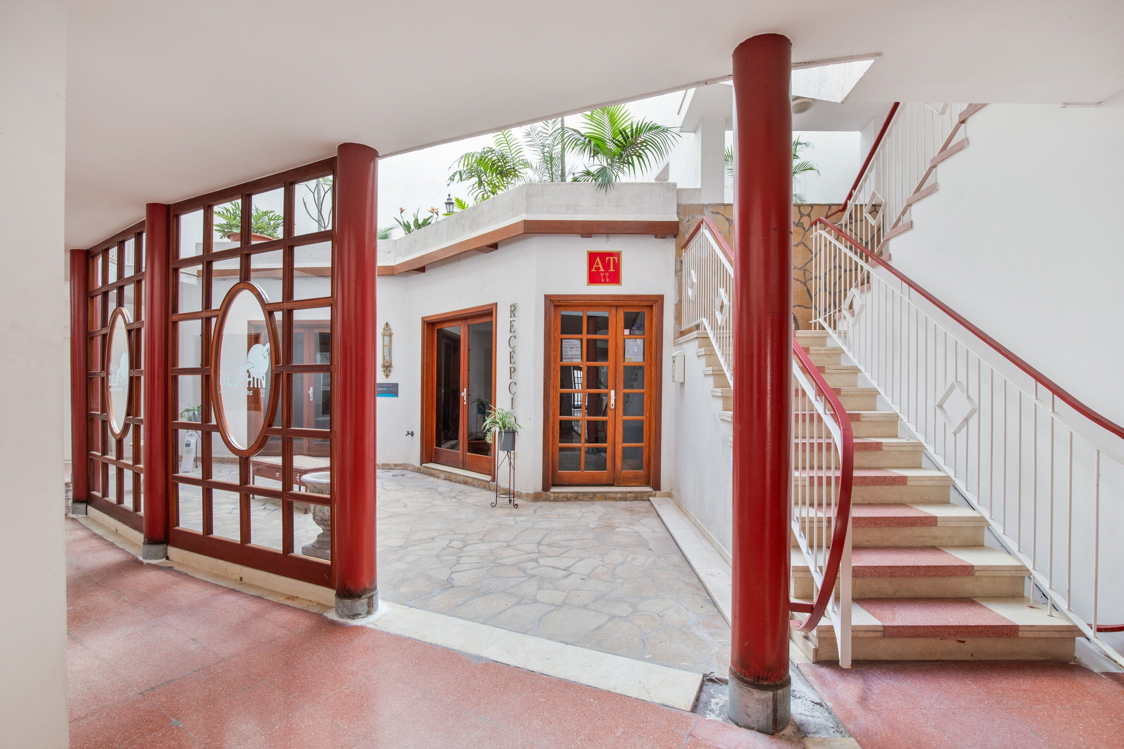 A reception area with a staircase, a reception desk, and a sign indicating the location.
