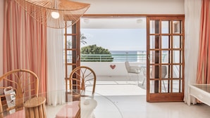 A room with a glass table, wicker chairs, a wicker umbrella, a view of the sea, and a balcony with a railing. - Apartment 'Playa Delphin 105' with Sea View, Balcony and Wi-Fi (Puerto de Naos)