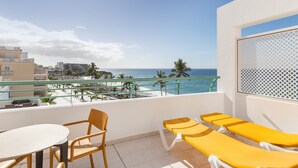 A balcony with a view of the ocean, yellow lounge chairs, a table, and chairs. - Apartment 'Playa Delphin 302' with Sea View, Balcony and Wi-Fi (Puerto de Naos)