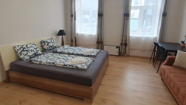 Quarto com cama, mesa e sofá.