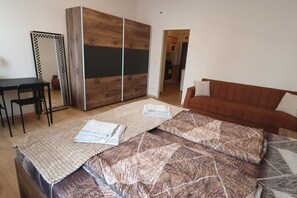 Une chambre à coucher comprenant un lit, un canapé, un bureau et une armoire.