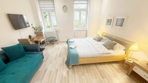 A bedroom with a bed, a sofa, a desk, and a TV. - Chic 1BR Apt Near Biggest Amusementpark of Vienna (Vienna)