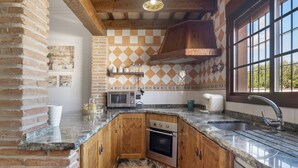 A kitchen with a built-in oven, a microwave, and a sink. - Holiday Home 'Villa' with Private Pool, Wi-Fi and Air Conditioning (Conil de la Frontera)