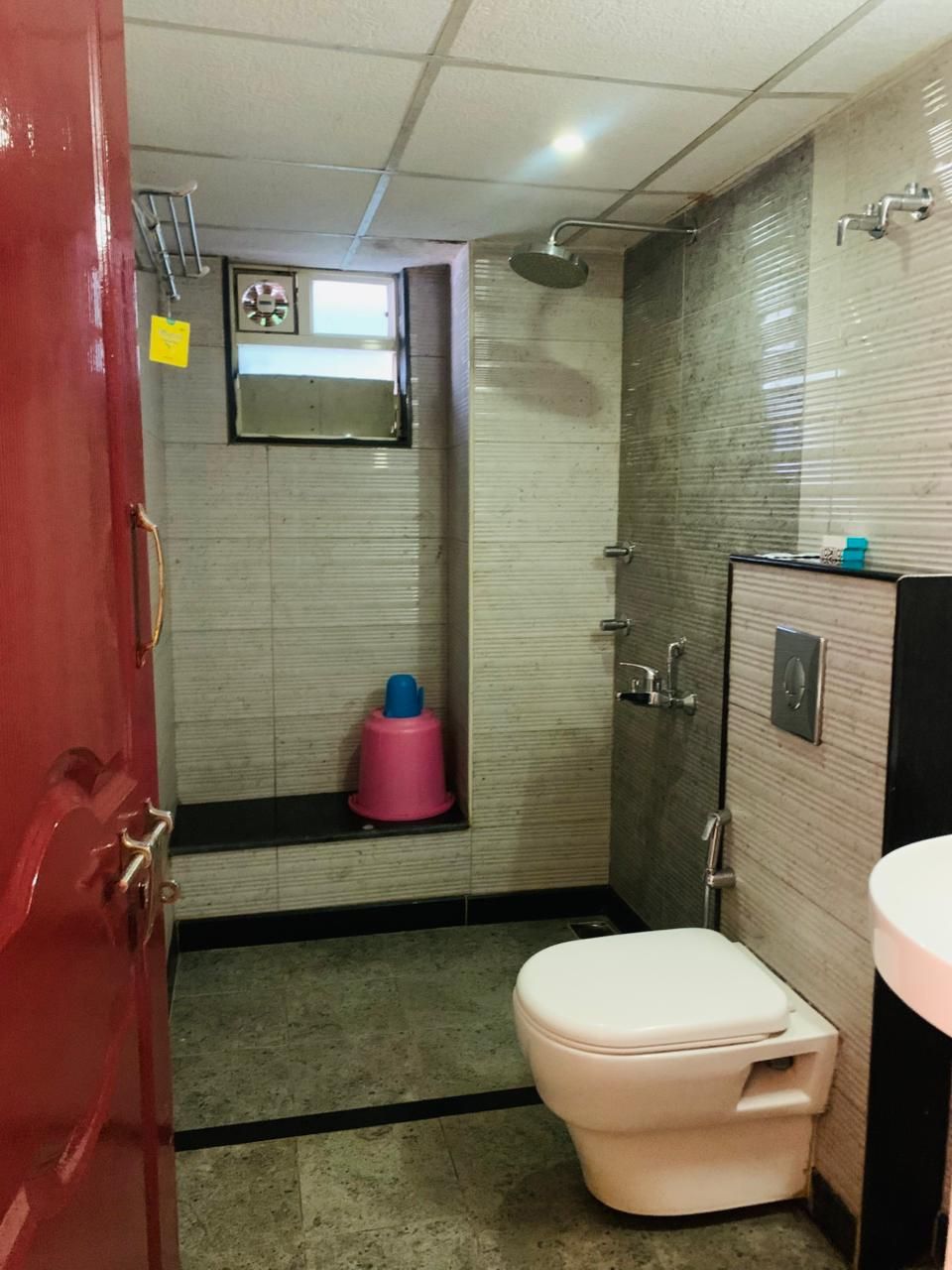 A small bathroom with a toilet, a shower, and a sink.
