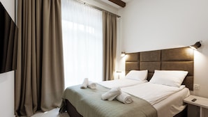 A hotel room with a large bed, two bedside tables, a headboard, and a window with curtains. - Apartamenty Sun & Snow Willa Zieleniec (Duszniki Zdroj)