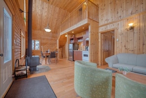 L’intérieur d’une cabane en rondins comprend un coin repas, une cuisine et un espace salon.