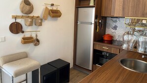 Een moderne keuken met houten kastjes, een roestvrijstalen koelkast en een zwart aanrechtblad met een spoelbak.