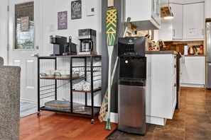 A modern kitchen with a coffee maker, a water dispenser, and a refrigerator. - Bécassines | Private Spa | Billiards | Waterfront (Nominingue)
