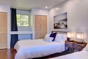 A bedroom with a bed, bedside lamps, a window with curtains, and a painting on the wall. - Bécassines | Private Spa | Billiards | Waterfront (Nominingue)