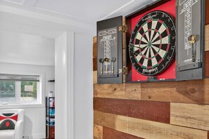 A dartboard mounted on a wall with a dartboard and a scoreboard below it. - Bécassines | Private Spa | Billiards | Waterfront (Nominingue)