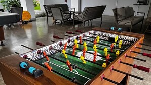 A foosball table in a room with a modern design, including a flat-screen TV and seating area. - Ocean View Apt | Beach Club | Playa Mantas (Punta Leona)