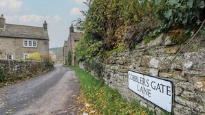A rural road with a stone wall and a sign reading "Cobblers Gate Lane". - Daleholme (Barnard Castle)