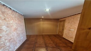 Un pasillo con suelo de baldosas y una puerta de madera.