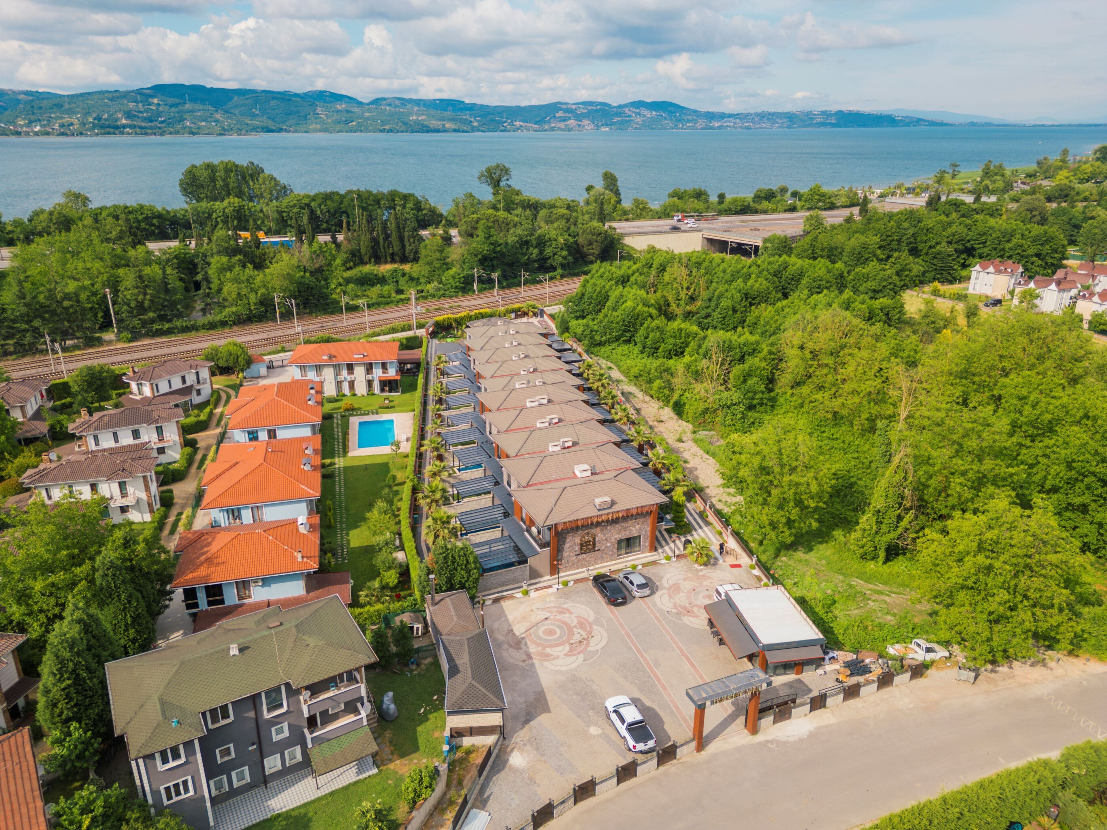 Vista aérea de una zona residencial con casas, una piscina y un estacionamiento.