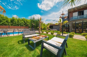 A poolside area with outdoor seating and a dining table set with food.