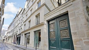 A row of historic buildings with large green doors and windows. - Family Apartment - Quartier Latin (Paris)