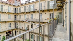 A multi-story building with balconies, railings, and a narrow pathway. - GuestHost - A comfortable, welcoming 40 square meters apartment, perfect for four people, located on the second floor of a period building (NO elevator).The property is located near the Vittorio Emanuele I Bridge in a quiet residential area, well-connect (Turin)