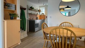 Una cocina con comedor, una mesa redonda y sillas.