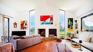 A living room with a sofa, a TV, a fireplace, and artwork on the walls. - Apartment 'Villa Ada' with Wi-Fi and Air Conditioning (Cozze)