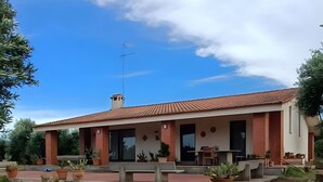 A house with a tiled roof, a porch with outdoor furniture, and a garden with potted plants. - Apartment 'Villa Ada' with Wi-Fi and Air Conditioning (Cozze)