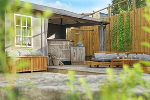 Un espace extérieur aménagé dans un style rustique, avec des bancs en bois et un chemin en pierre.