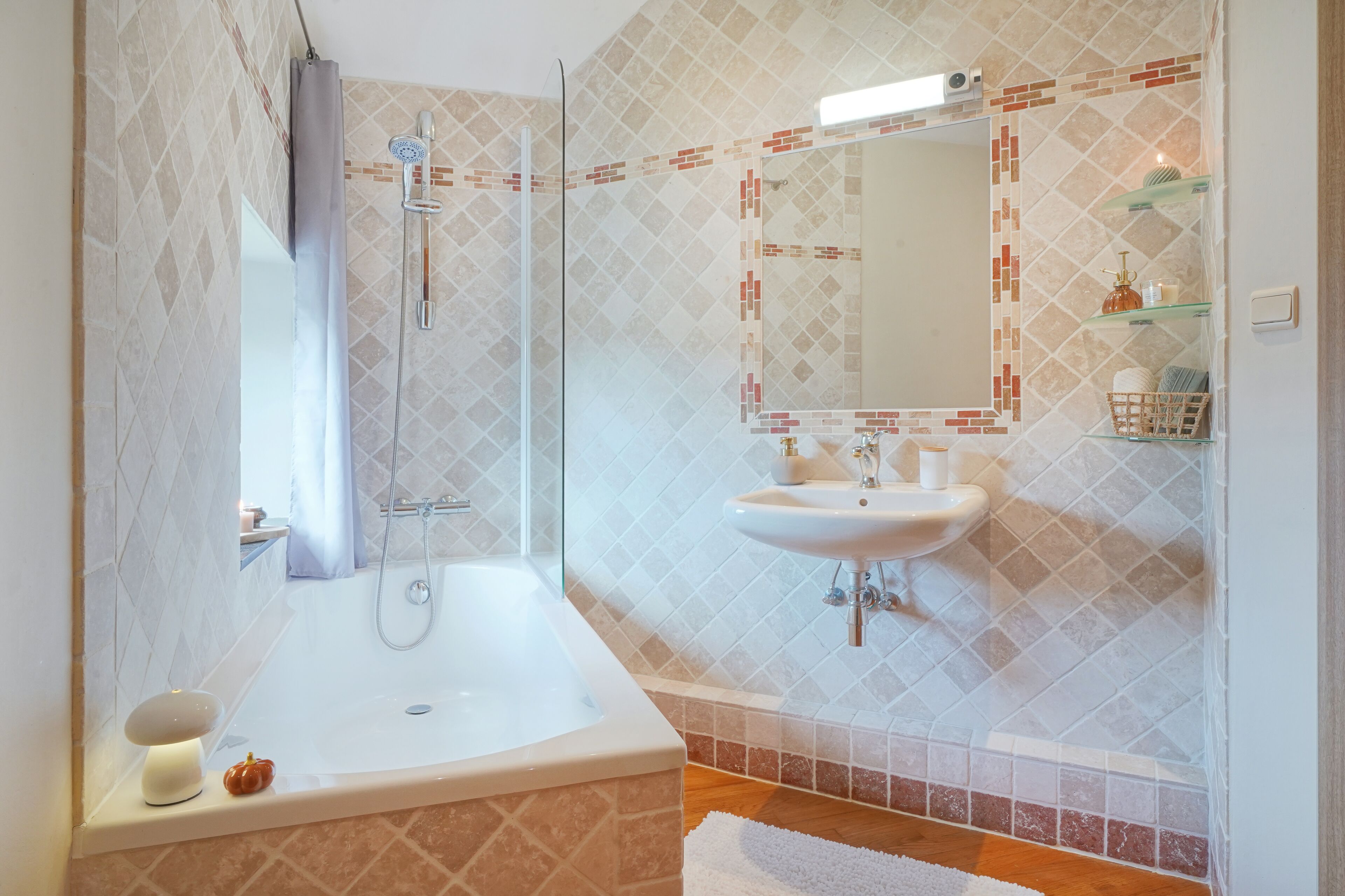 Un baño moderno con una bañera, una ducha, un lavamanos y un espejo.