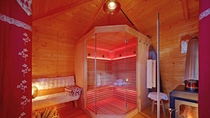 En hyggelig træhytte med sauna, pejs og en bænk med håndklæder.