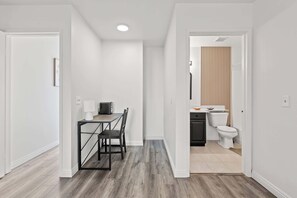 Eine moderne Küche mit schwarzer Arbeitsplatte, weißen Schränken und einer weißen Toilette.