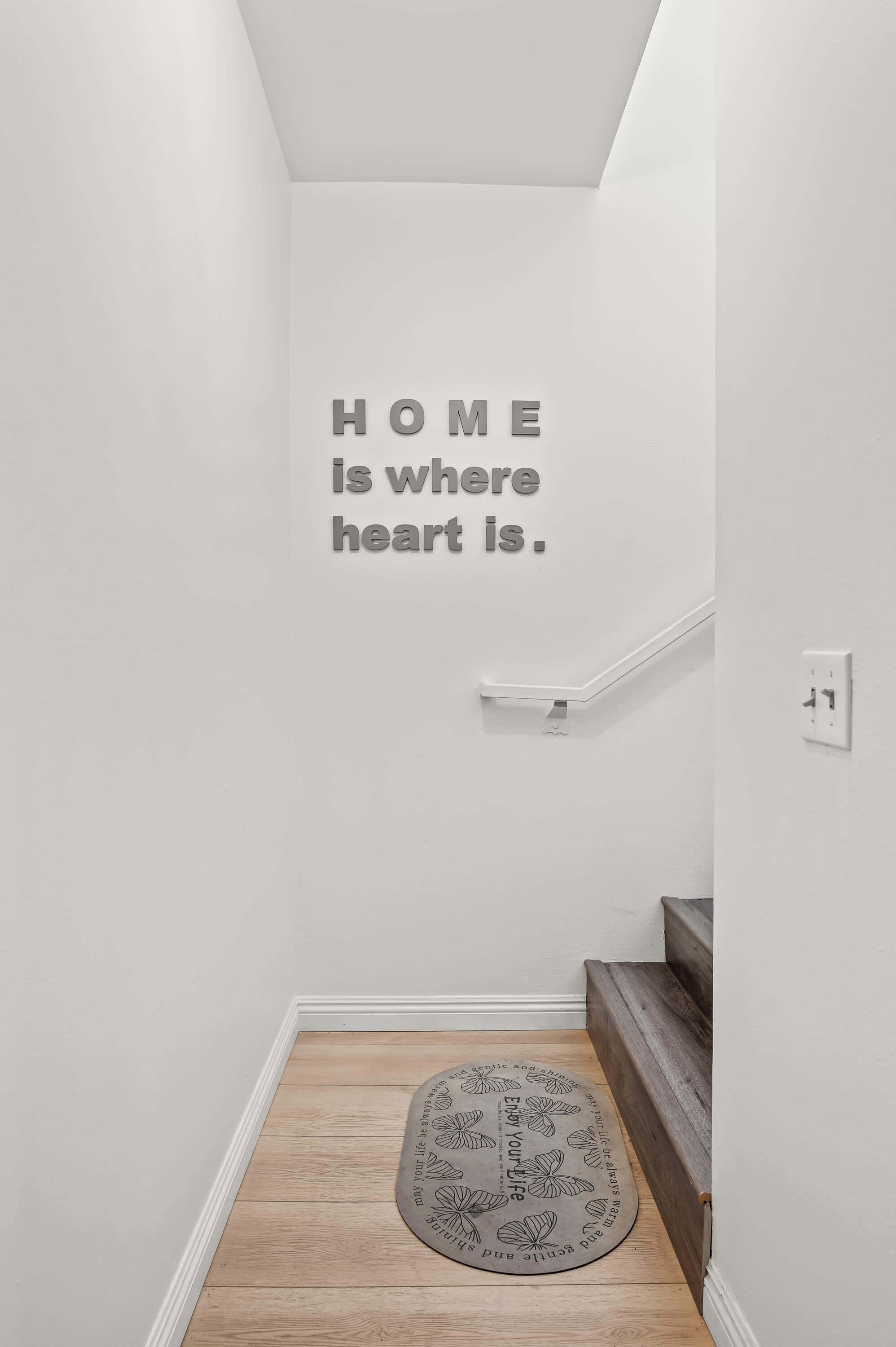 Una escalera con un letrero en la pared que dice 'HOGAR es donde está el corazón'.
