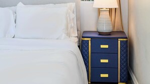 A bedroom with a bed, a bedside table with a lamp, and a window with curtains. - Modern Hotel-style Suite in Monterey Park Near LA (Monterey Park)