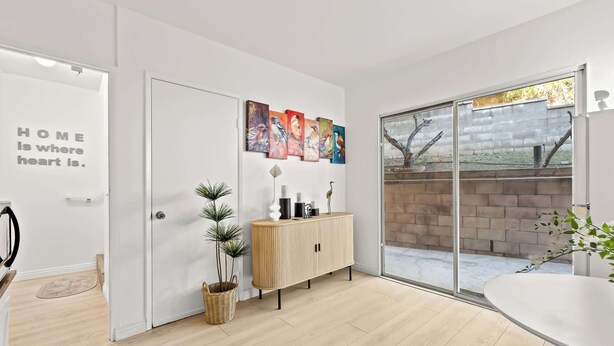 A modern interior with a white door, a wooden cabinet, and a glass door leading to an outdoor area. - Modern Hotel-style Suite in Monterey Park Near LA (Monterey Park)