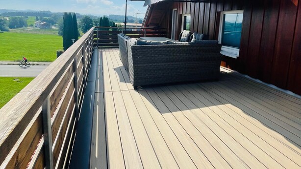 A wooden deck with a seating area and a view of the countryside. - Allgäunest Apartment with Mountain View, Private Terrace and Wi-Fi (Argenbühl)