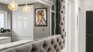 A tufted headboard in a modern room with pendant lighting and a framed artwork on the wall. - Best Location in London 3-bed Chelsea Home (London)