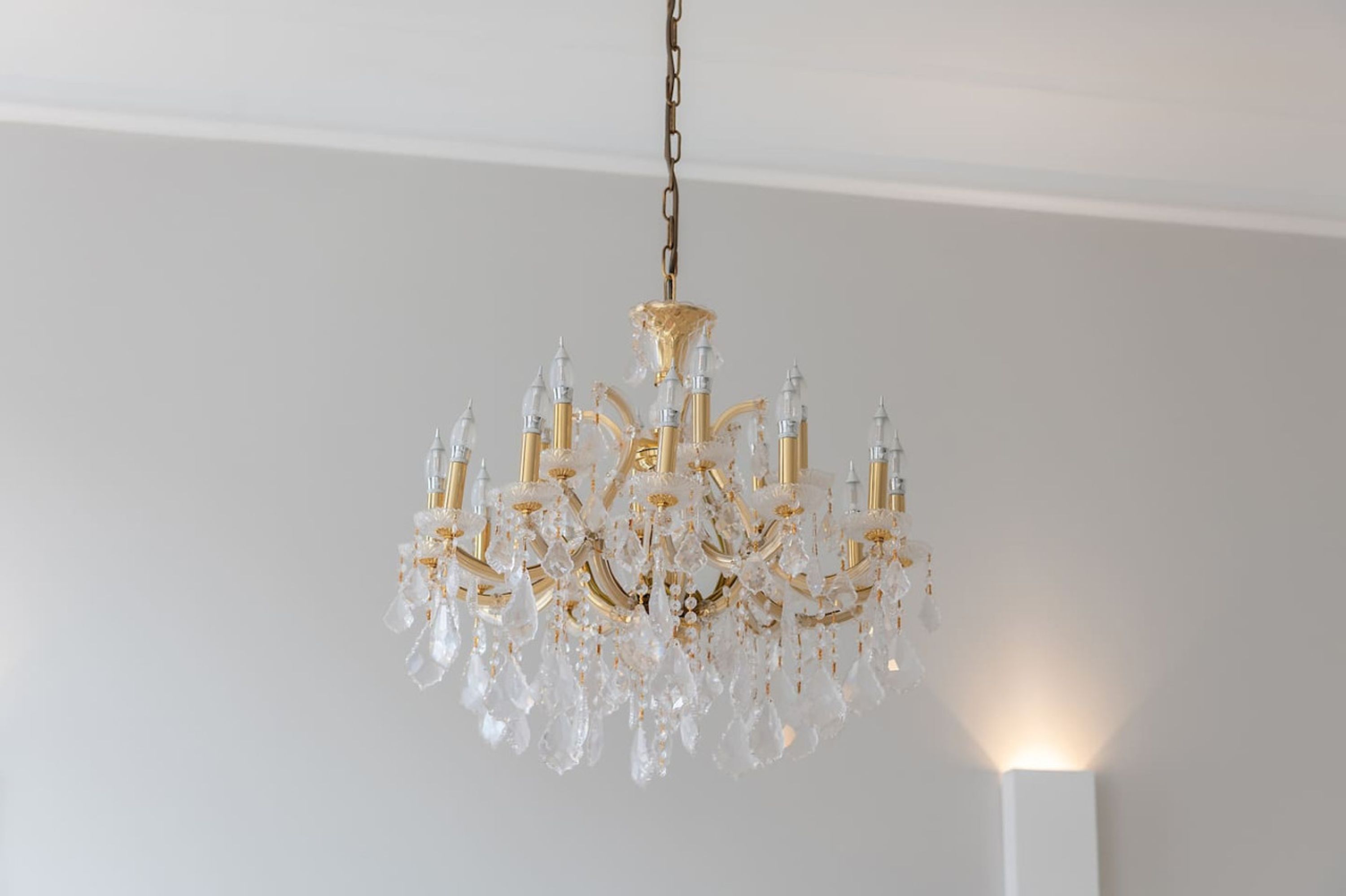 Een kroonluchter met meerdere armen en kristallen decoraties.
