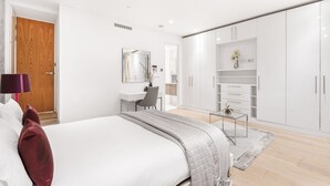 Um quarto moderno com uma cama, uma escrivaninha e um guarda-roupa.