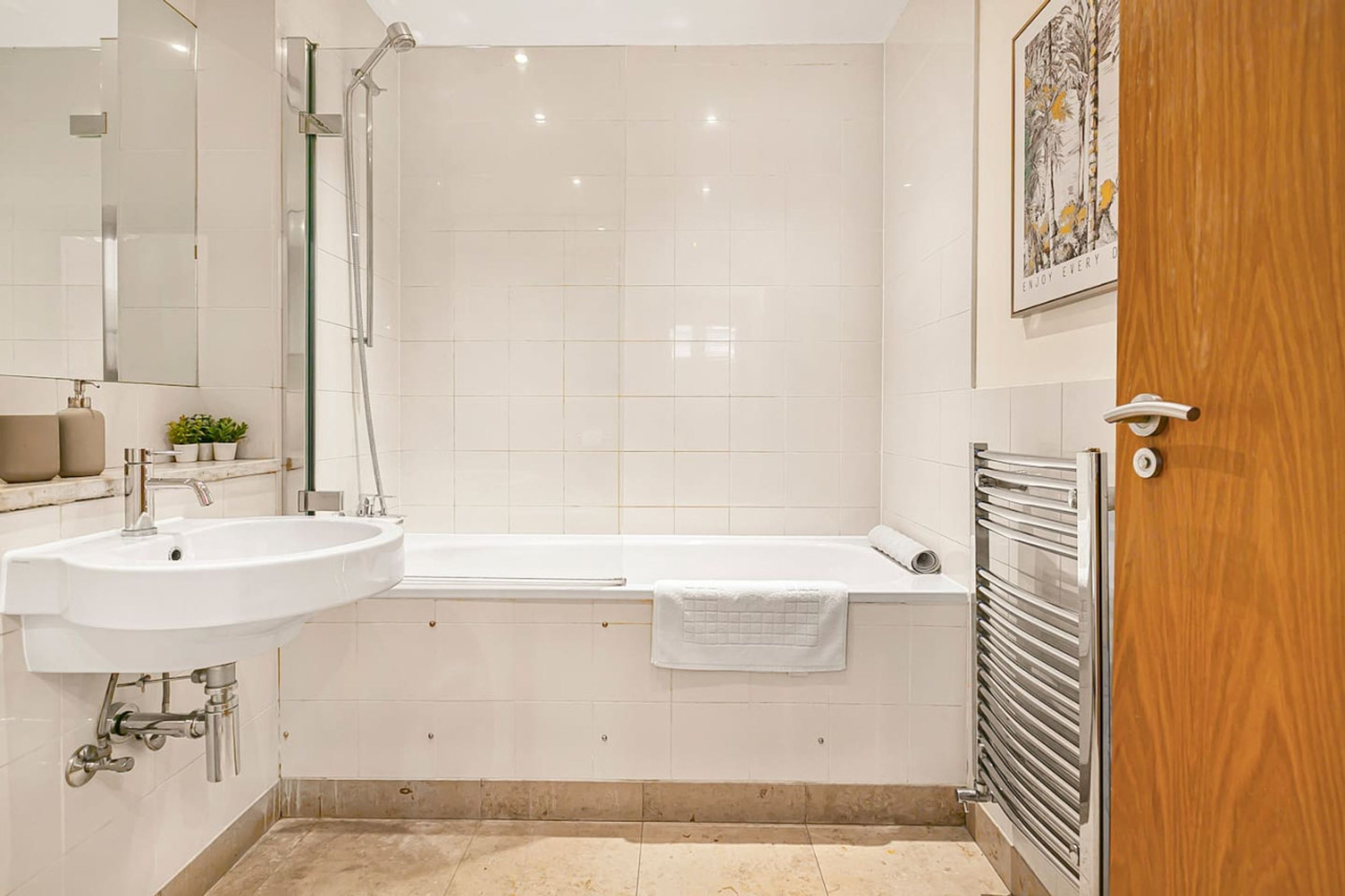 Une salle de bain moderne équipée d’un lavabo, d’un miroir, d’une douche et d’une baignoire.