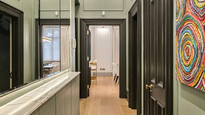 A hallway with a marble countertop, a dog, and a colorful abstract painting on the wall. - Ultra Luxury Holland Park Home - Central AC (London)