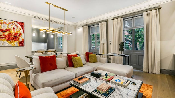 A modern living room with a sectional sofa, a coffee table with books, and a large window with curtains. - Ultra Luxury Holland Park Home - Central AC (London)