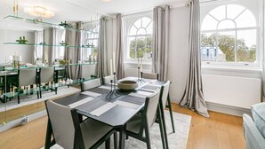Un'area pranzo moderna con un tavolo in vetro, sedie e un grande specchio.
