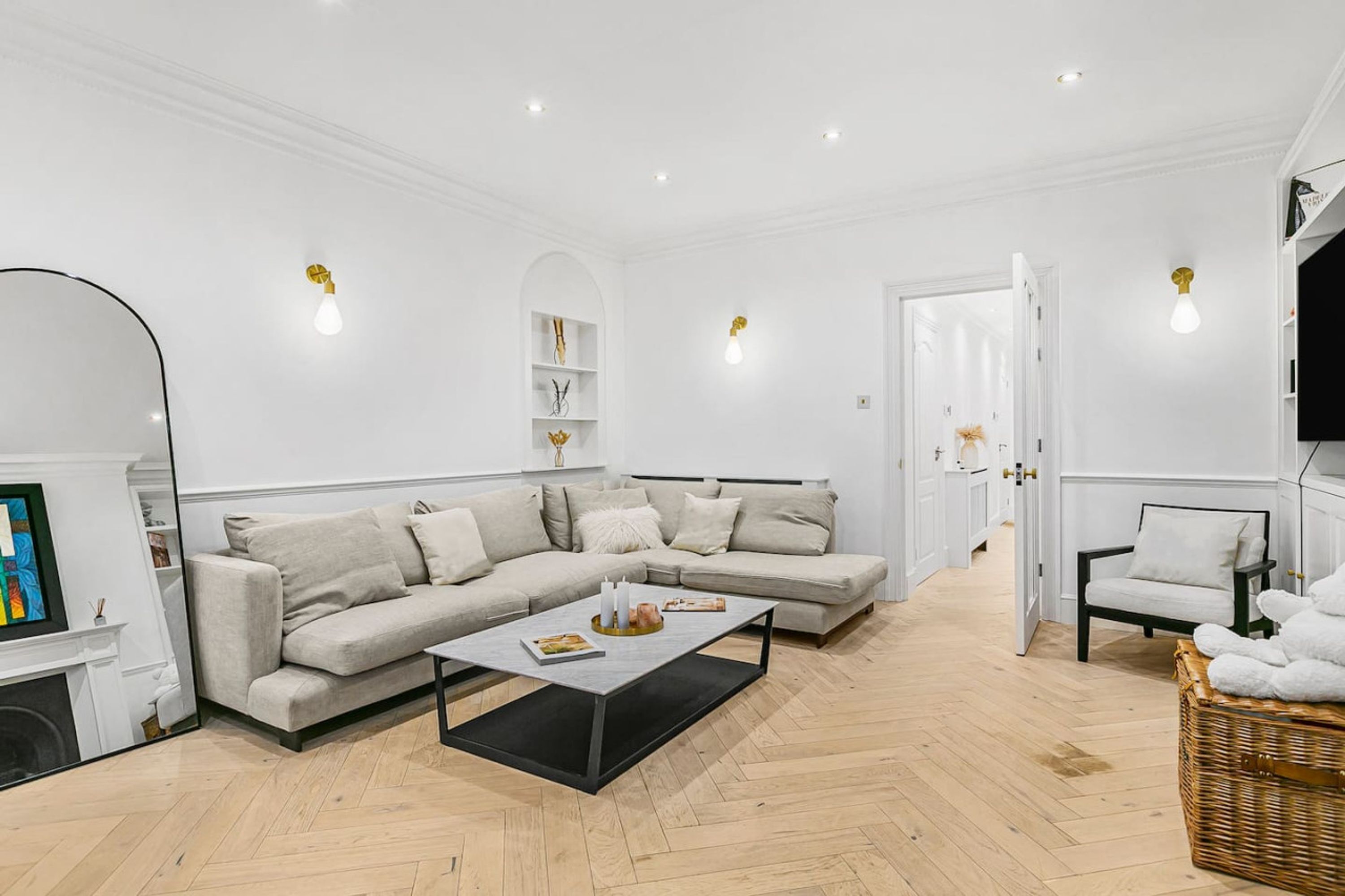 Un salon moderne avec un canapé d’angle beige, une table basse et une cheminée.