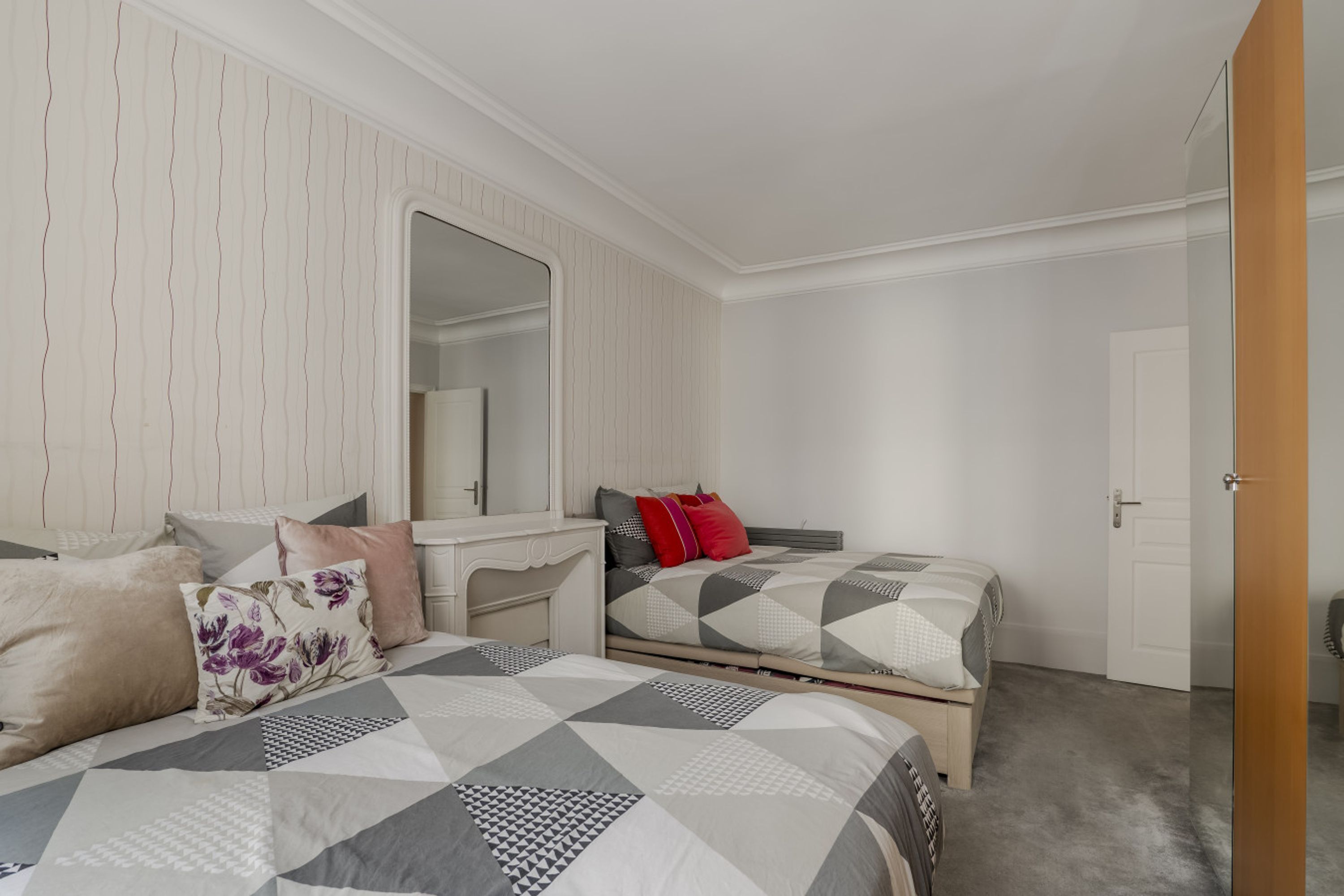 Une chambre à coucher avec un lit, une table de chevet et un miroir.